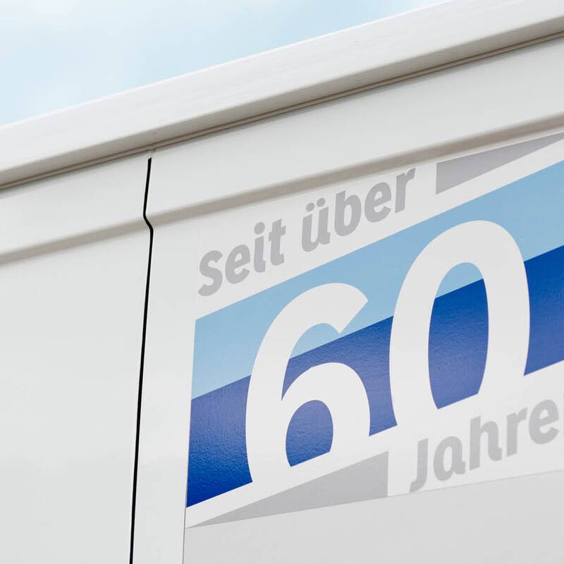Jubiläumslogo „über 60 Jahre“ beschriftet auf einen Bus. Fotoreportage für Fensterbau Glaserei Vosseler