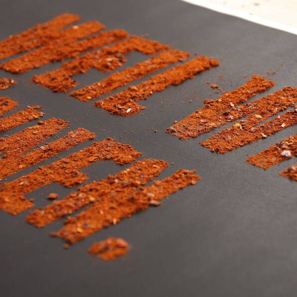 Spruch „Weil wirs können“, gelegt aus Chiliflocken, Projekt Rostkantwurst