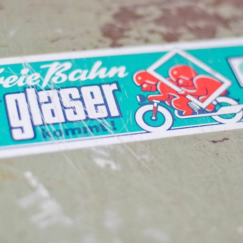 Fotodetail historischer Sticker „Freie Bahn, der Glaser kommt!“ auf Werkzeugkiste, Fotoreportage für Fensterbau Glaserei Vosseler