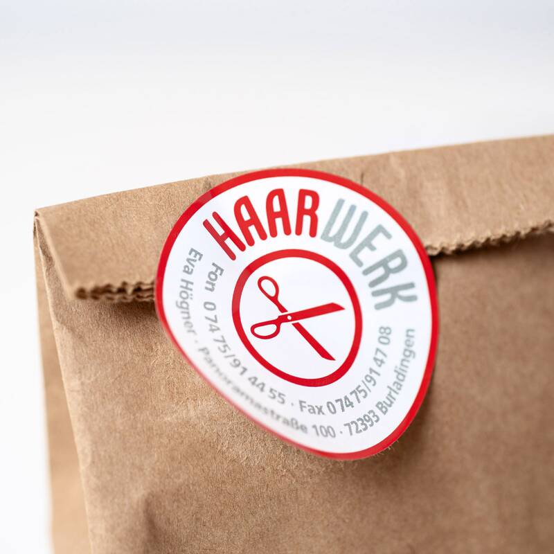 Fotodetail eines Stickers von Haarwerk Eva Högner an einer braunen Kraftpapiertüte
