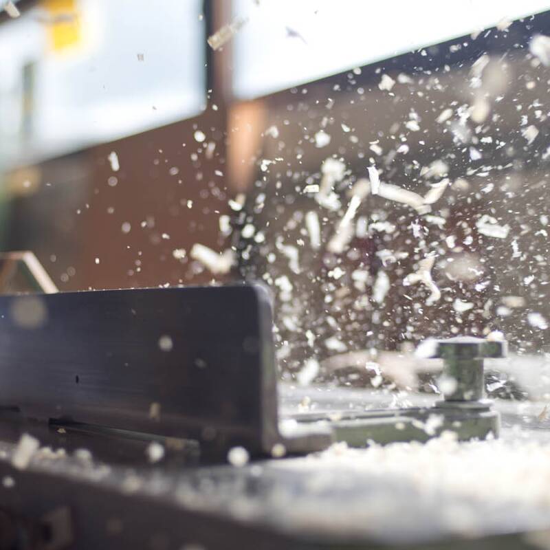 Fotodetail der Fräsmaschine, fliegende Späne. Fotoreportage für Fensterbau Glaserei Vosseler